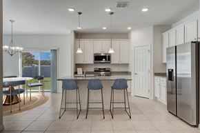 Kissimmee townhouse for rent - A modern kitchen with a bar area and a refrigerator on the right.