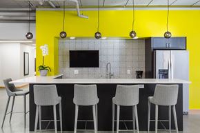 Minneapolis apartment for rent - a kitchen with yellow walls and a counter with chairs