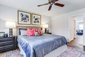 Fort Wayne townhouse for rent - the master bedroom has a large bed and a ceiling fan