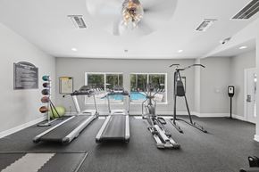Calera apartment for rent - Bright resident fitness center at Lancaster Place Apartments in Calera, Alabama featuring treadmills, weight equipment, and spacious workout areas.