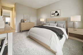 Aurora apartment for rent - A bedroom with a large bed and a nightstand with a lamp.