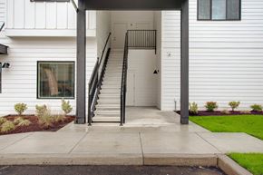 Vancouver apartment for rent - the front entrance of a white house with a staircase