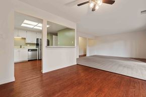 Fremont apartment for rent - an empty living room and kitchen with wood floors and a ceiling fan