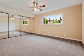 Fremont apartment for rent - Three-Bedroom Apartments in Fremont, CA - Logan Park Apartments - Bright Bedroom With Mirrored Closet Doors, Soft Carpet, Ceiling Fan, and Wide Window.