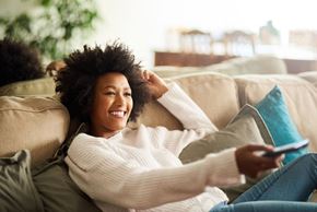 Delaware apartment for rent - a woman laying on a couch with a remote control