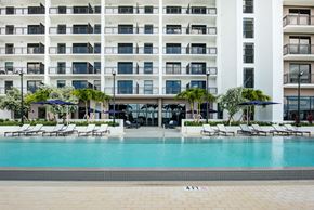 Miami apartment for rent - Apartments for Rent in Miami, FL - MB Station - Resort Style Pool With Lounge Chairs, Navy Umbrellas, And Modern Apartment Building With Balconies And Glass Doors.