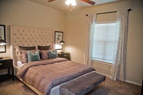 Raymore apartment for rent - A bedroom with a large bed and a ceiling fan.