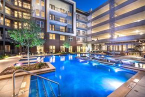 Dallas apartment for rent - A large indoor swimming pool with a slide in a residential building.