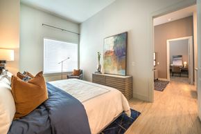 Dallas apartment for rent - A bedroom with a large bed and a painting on the wall.