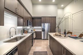Dallas apartment for rent - A modern kitchen with dark wood cabinets and stainless steel appliances.