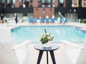 Edina apartment for rent - a vase of flowers on a table next to a swimming pool