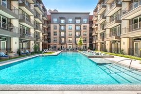 Dallas apartment for rent - A large swimming pool in the middle of a courtyard surrounded by apartment buildings.