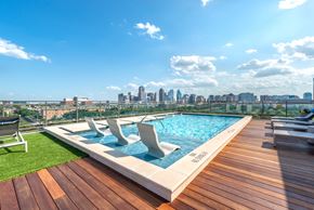 Dallas apartment for rent - A rooftop pool with a city skyline in the background.