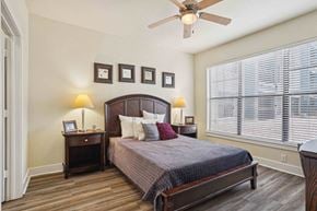 North Little Rock apartment for rent - 1, 2 -Bedroom Apartments for Rent in North Little Rock, AR – Metropolitan– A bedroom with a bed, nightstands, and a ceiling fan.