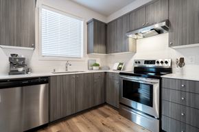 Vancouver apartment for rent - Vancouver, WA, Apartments Near Walnut Grove Park - Minnehaha Meadows - Kitchen with Vinyl Plank Flooring, Wood Cabinetry, Windows with Blinds, and Stainless Steel Appliances.
