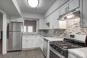 Clarkston apartment for rent - Kitchen at Mirador at Idlewood in Clarkston, GA, featuring energy-efficient appliances including refrigerator, gas stove, dishwasher, and garbage disposal; select units offer upgraded stainless steel finishes.
