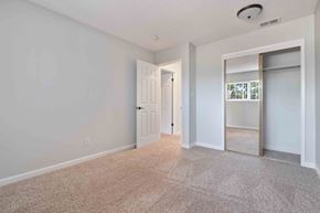 Gilroy apartment for rent - Two-Bedroom Apartments in Gilroy, CA - Mission Park - Unfurnished Bedroom with Carpeted Flooring, Large Closet, Sliding Mirror Doors with Gold Trim, Soft Grey Walls, and Overhead Light.