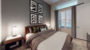 Dallas apartment for rent - A bedroom with a large bed and a lamp on a side table.