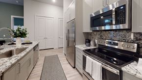 Dallas apartment for rent - A modern kitchen with a stainless steel refrigerator and oven.
