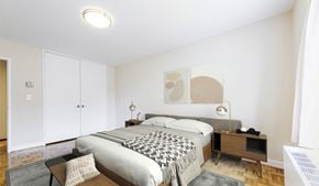 Washington apartment for rent - A bedroom with a large bed and a nightstand with a lamp.