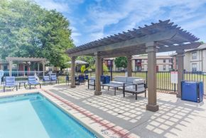 Aurora apartment for rent - A pool area with a pergola and lounge chairs.
