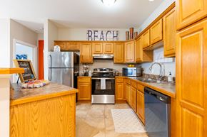 Biloxi apartment for rent - A kitchen with wooden cabinets and a sign that says beach.
