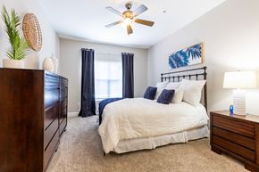 Biloxi apartment for rent - A bedroom with a bed, nightstand, and a ceiling fan.