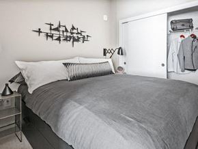 Seattle apartment for rent - One-Bedroom Modern Apartments in Seattle, WA - Origin - Bedroom with Bed, Nightstand with Lamp, Wall Art, Spacious Closet, and Grey Carpet