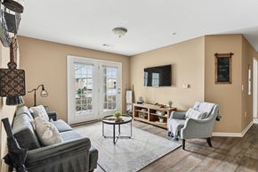 Sevierville apartment for rent - Pet-Friendly Rentals in Sevierville, TN – Overlook at Allensville – A living room with a grey couch, a coffee table, a chair, and a lamp.