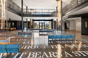 Houston apartment for rent - A large open room inside The Laura office with a floor that has a quote on it.