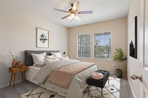 Rogers apartment for rent - 1, 2 & 3-Bedroom Apartments for Rent in Rogers, AR – Parc at Rogers– A bedroom with a bed, a chair, and a ceiling fan.