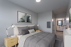 Sherwood apartment for rent - a bedroom with grey walls and a bed with a white comforter