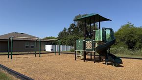Ruskin apartment for rent - A playground with a green slide and a sign with letters and numbers.