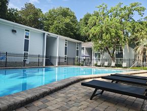 Gainesville apartment for rent - A pool surrounded by a black fence and a bench.
