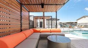 Phoenix apartment for rent - A wooden pergola with orange cushioned seating.
