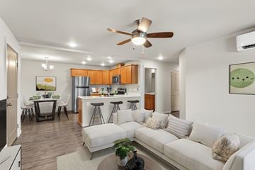 Vancouver apartment for rent - A modern living room with a white couch and a ceiling fan.