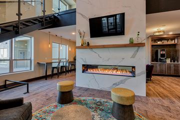 Coon Rapids apartment for rent - A living room with a fireplace and a television mounted above it.