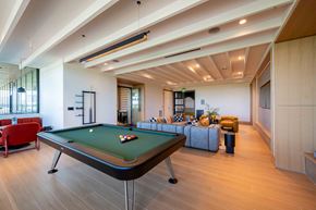 Raleigh apartment for rent - A pool table is in the middle of a room with a couch and a chair.