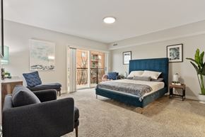 Des Plaines apartment for rent - Spacious primary bedroom with wood-style flooring and natural light at River 595