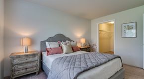 Coeur D Alene apartment for rent - Apartments For Rent In Coeur d'Alene, ID - Rockwood Lodge - Bedroom With Carpeted Flooring, Large Bed, Wooden Nightstands With Lamps, And Spacious Closet.