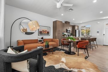 Phoenix apartment for rent - A living room with a brown leather couch and a black and white cowhide rug.