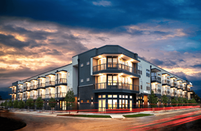 Dallas apartment for rent - A modern apartment building with a curved facade and balconies is illuminated at dusk.