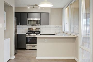 Tempe apartment for rent - a white kitchen with black cabinets and a microwave