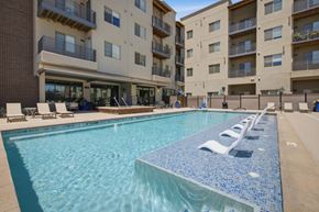 Greeley apartment for rent - A large swimming pool in front of apartment buildings.