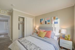 Moreno Valley apartment for rent - One-Bedroom Apartments in Moreno Valley, CA - Ardella on Chagall - Bedroom with Carpeted Flooring, Bed, Nightstands with Lamps, Cream-Colored Walls, and Large Closet.