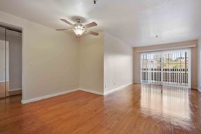 Daly City apartment for rent - 1-Bedroom Apartments in Daly City, CA - Serra Commons - Open Living Area With Wood Style Flooring, Ceiling Fan, Mirrored Closet Doors, And Sliding Glass Door To Balcony.