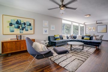 Belmont apartment for rent - A living room with a grey chair and a brown cabinet.