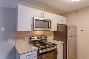 Fridley apartment for rent - a kitchen with stainless steel appliances and white cabinets