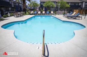 Tempe apartment for rent - A swimming pool with a diving board and lounge chairs.
