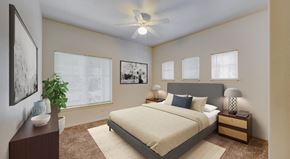 Flagstaff apartment for rent - A bedroom with a large bed, a ceiling fan, and a potted plant.